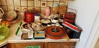 Overview of assorted Asian serving dishes, tea sets, and chopsticks including bowls, trays, and stacked cups on a countertop.