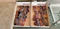 Two cardboard trays side by side filled with various sunglasses