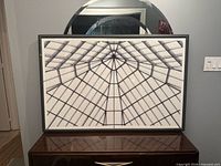 Front view of framed geometric print on dresser