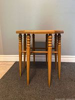 Oblique view showing eight turned and tapered legs and wood grain finish