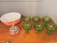 Group view of mixing bowl, six green dessert bowls, and lidded jar