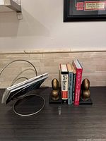Bookends supporting books beside circular metal magazine holder