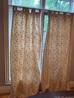 Full view of both cream/gold embroidered curtain panels hanging