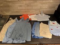 Overview of nine Gymboree garments laid out