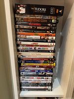 Full stack of DVDs on shelf showing spines