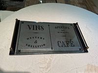 Front view of mirrored glass serving tray showing French text, metal frame and handles