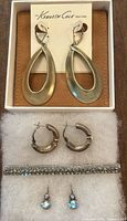 Overview of all earrings and brooch together on display pad