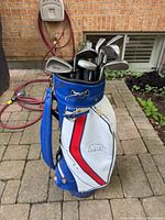 Full view of blue and white golf bag with clubs