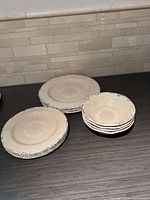 Stacked dinner plates and bowls showing color and rim detail