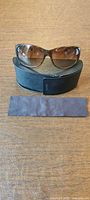 Front view of sunglasses on case with cloth
