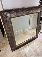 Full view of rectangular mirror leaning against wall