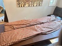 Two folded plaid curtain panels on table