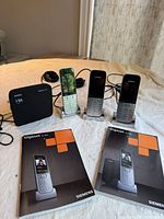Front view showing base station, three handsets on charging cradles, two manuals and power cords