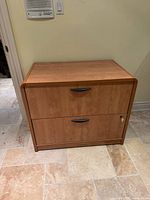 Front view showing two drawers, finish, handles, lock