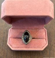 Ring in open pink ring box showing marquise black stone and marcasite halo