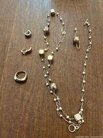 Full view of necklace, ring, earrings on tabletop