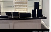 Front view of Klipsch center channel and six satellite speakers on countertop