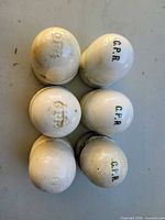 Top view of six white porcelain insulators marked C.P.R.