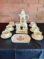 full set arranged on table showing coffee pot, creamer, sugar, cups, saucers, and small tray