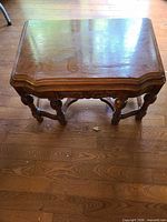 Top view of rectangular brown veneer coffee table showing scalloped edge and wear