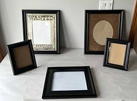 Front view of all five black frames displayed on table showing sizes and styles