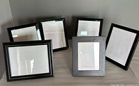 Front view of six black picture frames assorted sizes