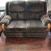 Front view of brown striped fabric manual reclining loveseat showing full piece