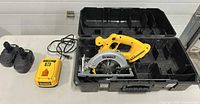 Saw, charger, two batteries, open case overview