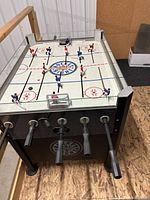 Full view of Hockey Night rod hockey table showing cabinet, rods, and glass top