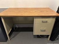 Full view of desk showing laminate top, metal frame, drawer pedestal