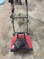 Rear view of red King Canada electric snow thrower with handle and cord retainer