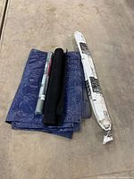 All four items: folded blue tarp, black vinyl roll, grey foam roll, white-wrapped vapour barrier