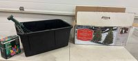 Overall lot showing black storage tote with stakes, Sylvania light box, and opened tree carton