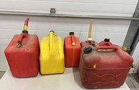 Front view of all five fuel cans lined up showing colors, sizes and spouts