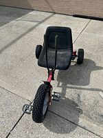 Full view of pedal go-kart from front showing frame, seat, wheels, steering levers