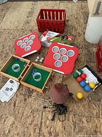 Overview showing bocce balls, bean bag boards, tabletop game boxes, basketball, pump and crate