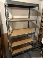 Full view of steel shelving unit showing five shelves and overall structure