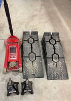 Red Torin floor jack, two Pro.Point jack stands, two Rhino ramps on concrete floor