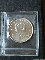 Obverse of coin showing King George VI effigy in holder