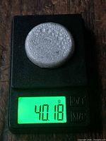 Ingot puck on scale showing 40.18 g and porous surface
