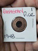 Obverse of coin in holder showing ‘ONE PICE’ design and date
