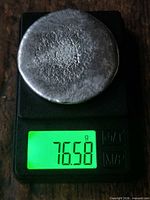 Top view of pewter ingot on digital scale showing weight 76.58 g