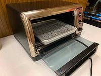 Toaster oven open showing interior tray and rack