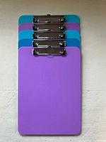Five clipboards stacked showing color assortment and clips