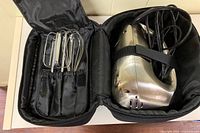 Open carrying case showing mixer body secured and attachments in elastic pockets