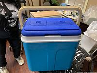Front perspective of blue Flair cooler with handle raised