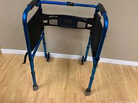 Front view of metallic blue folding walker showing two front wheels and mesh side panels
