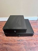 Two stacked black metal drawer units