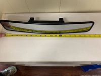 Top view showing full length of mirror with measuring tape indicating about 17 inches