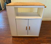 Front view showing open shelf, double doors, wood top